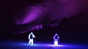 Dos esquiadores ataviados con trajes brillantes se deslizaron por una montaña. ¡