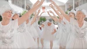 9 señoras mayores vestidas de blanco están bailando y cantando. ¡Fíjaos en la ab